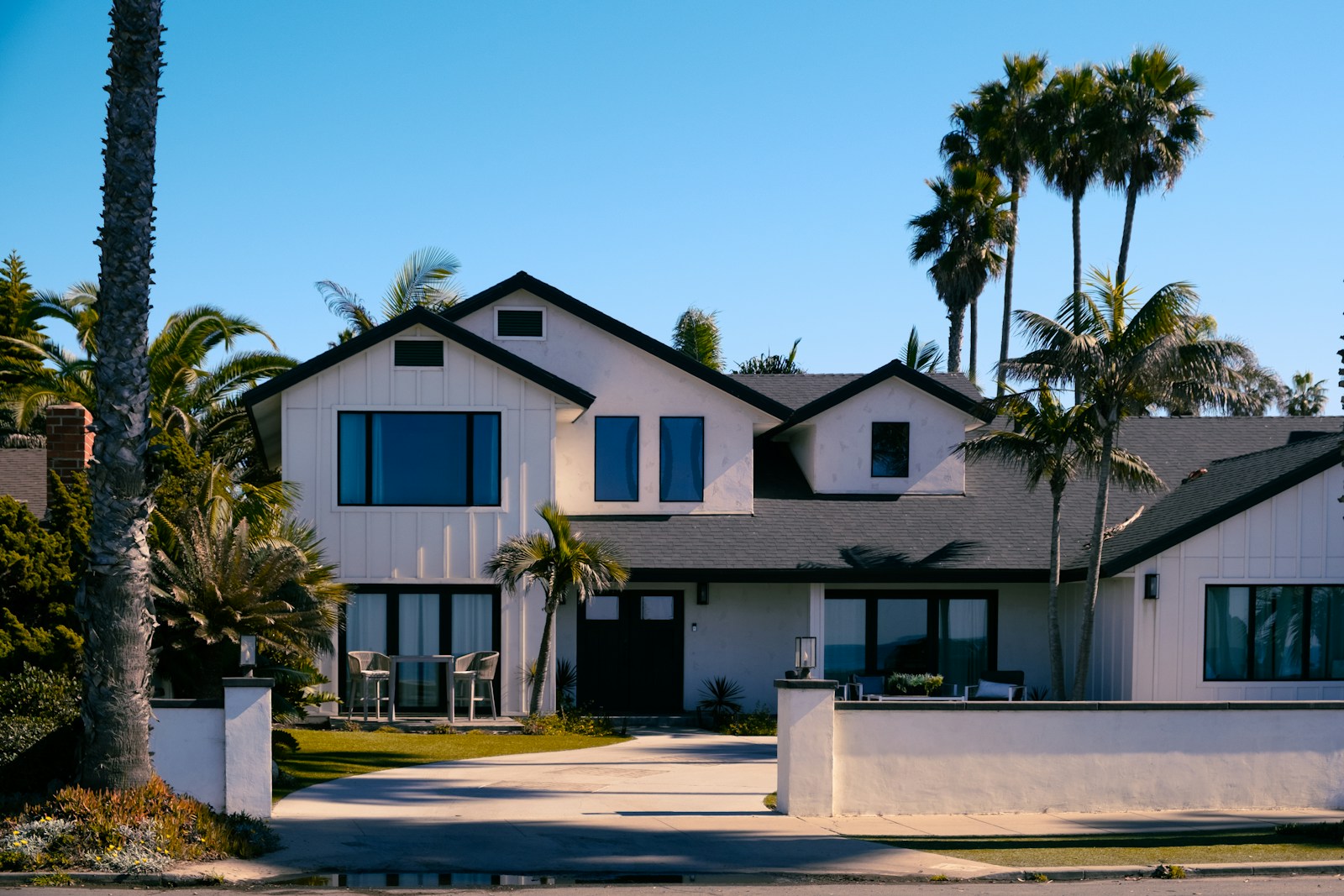 Beautiful white house with palm trees in the background.