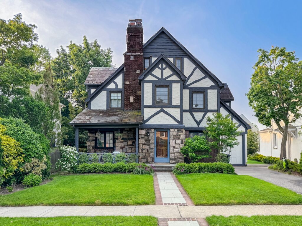A charming tudor-style home with a beautiful yard.